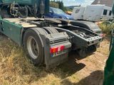 a green semi truck that is parked on the side of the road