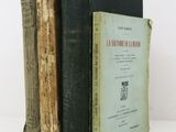 two old books are stacked on top of each other on a table
