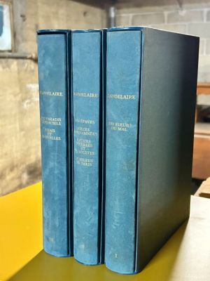 three blue books sitting on top of a yellow table next to each other