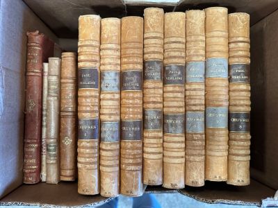 many old books in a box on a blue cloth