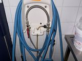 a white toilet with a blue hose attached to it