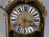 a gold clock with blue and white stripes on it