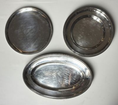 trois plateaux en argent posés sur une table blanche