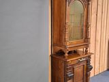 a tall wooden cabinet with a mirror on top of it