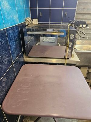 a small table with a pink top in a blue tiled room