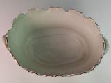 a white bowl with a green rim sitting on a table