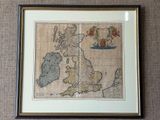 an old map of the british isles in a frame on a wall