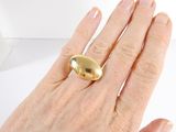 a woman ' s hand with a gold ring on it