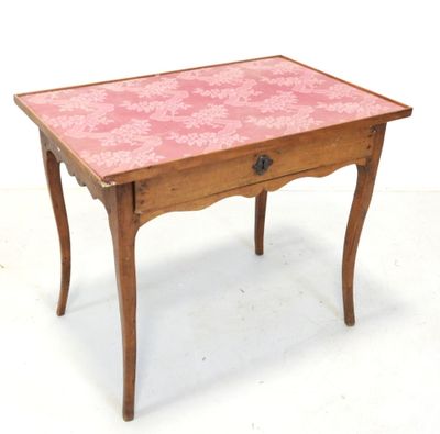 une petite table en bois recouverte d'une nappe rose