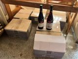 two bottles of wine sitting on top of boxes on the floor
