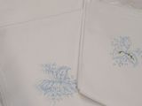 four white napkins with blue embroiderys on them