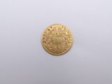 a close up of a gold coin on a white surface