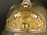 a silver helmet with a gold crest on it