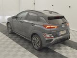 the rear end of a gray car parked in a garage