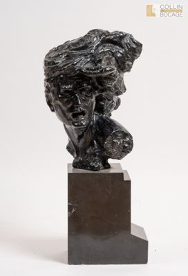 la statue d'un homme est assise au sommet d'un bloc de marbre