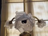 a glass vase with a flower on it in front of a window