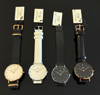 Quatre modèles de montres différents sont présentés sur un fond noir
