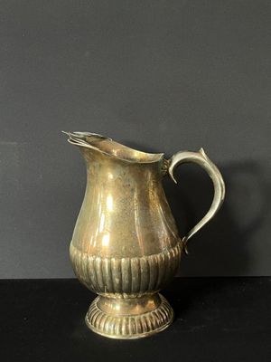 a silver pitcher that is sitting on a table
