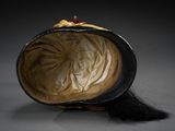 an old hat with a long black hair sitting on top of a table