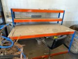 a workbench with a desk and a chair in the room