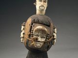 une image représentant une sculpture en bois d'un homme portant un enfant