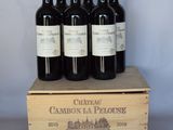 quatre bouteilles de vin rouge dans un coffret en bois posé sur une table