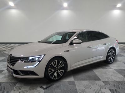 la voiture blanche est garée sur un sol en damier dans le garage