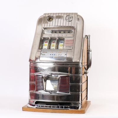 une machine à sous argentée posée sur un socle en bois