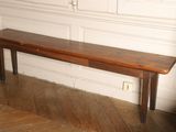 a wooden bench in the corner of a room