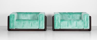 une paire de fauteuils en velours vert, avec des pieds et des accoudoirs noirs