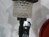 une lampe en verre posée au sommet d'un poteau métallique