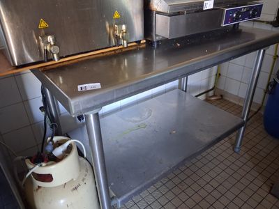 a metal counter with a metal oven on top of it