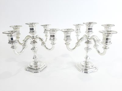 trois chandeliers en argent sur fond blanc, avec un fond blanc