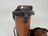pair of leather boots and a leather bag on a white surface