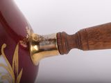 a close up of a vase with a wooden handle