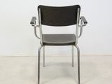 an image of a black chair in a room with a white wall