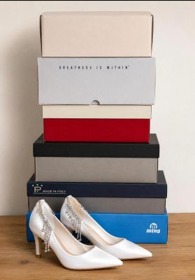 a pair of white shoes sitting on top of a stack of boxes