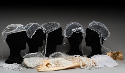 trois têtes de mannequin ornées de voiles blancs et de dentelle