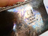 a person holding a silver plate with a tag on it