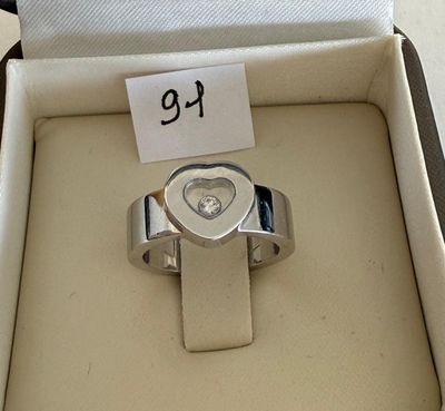 a silver ring with a heart on it in a box