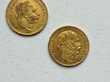 two pieces of gold coins on a white surface