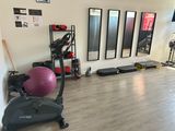 une salle de sport équipée d'appareils de musculation et de miroirs aux murs