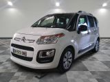 la petite camionnette blanche est garée sur un carrelage à carreaux