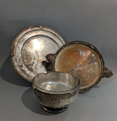 deux plats en argent et un bol en argent posés sur un plan de travail gris