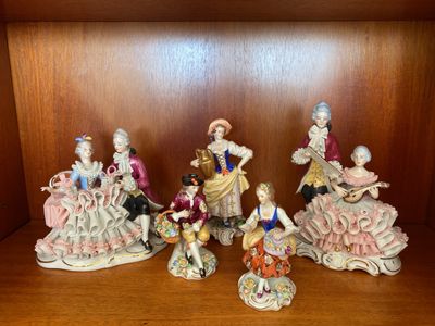cinq figurines représentant des personnes assises sur une étagère
