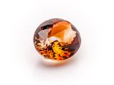 a close up view of a faceted orange sapphire stone on a white surface