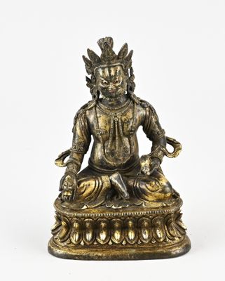 une statue en bronze représentant un Bouddha assis sur un socle