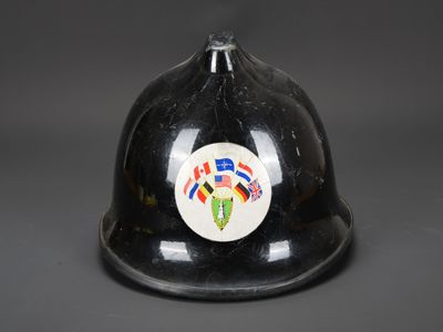 un vieux casque de pompier sur lequel est collé un autocollant