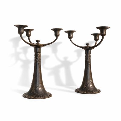 une paire de bougeoirs anciens en bronze sur fond blanc