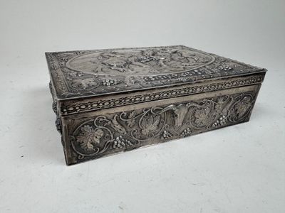 an antique silver box with a floral design on the lid